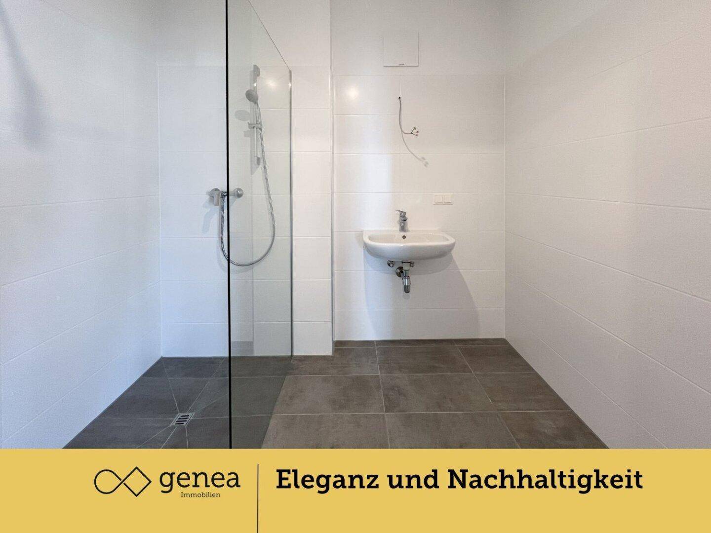 Modernes Badezimmer mit ebenerdiger Dusche, weißen Fliesen und einem kleinen Waschbecken.