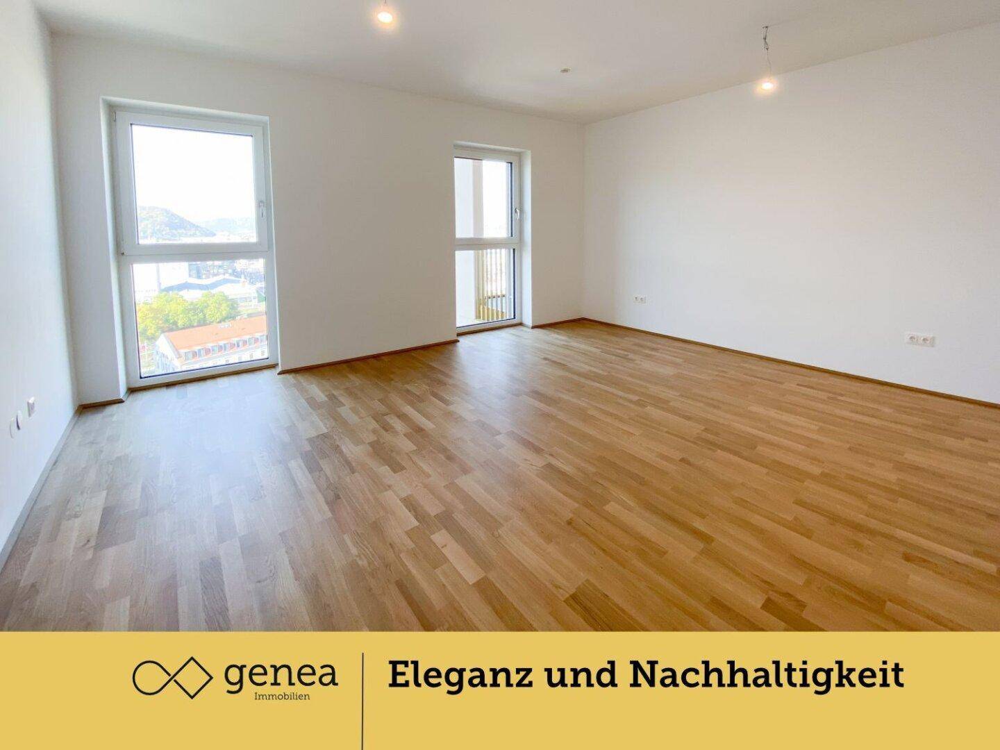 Heller Raum mit Parkettboden und zwei großen Fenstern, die einen weiten Blick auf die Landschaft bieten.