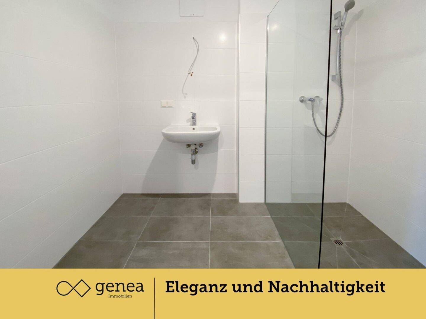 Modernes Badezimmer mit weißen Fliesen, ebenerdiger Dusche und einem einzelnen Waschbecken.