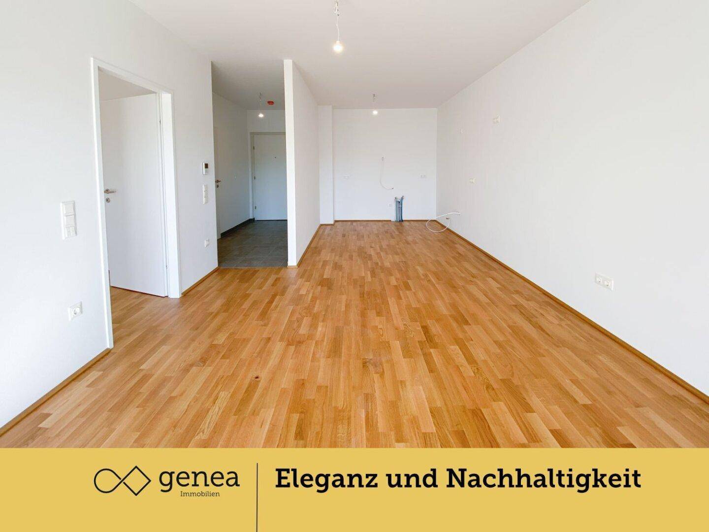 Geräumiger, heller Wohnbereich mit Parkettboden und Zugang zu einem gefliesten Flur.