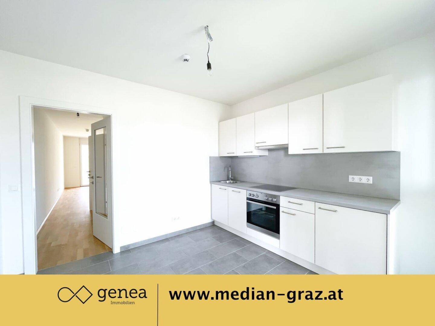 Moderne Einbauküche in Weiß mit grauer Arbeitsplatte und Fliesenboden.