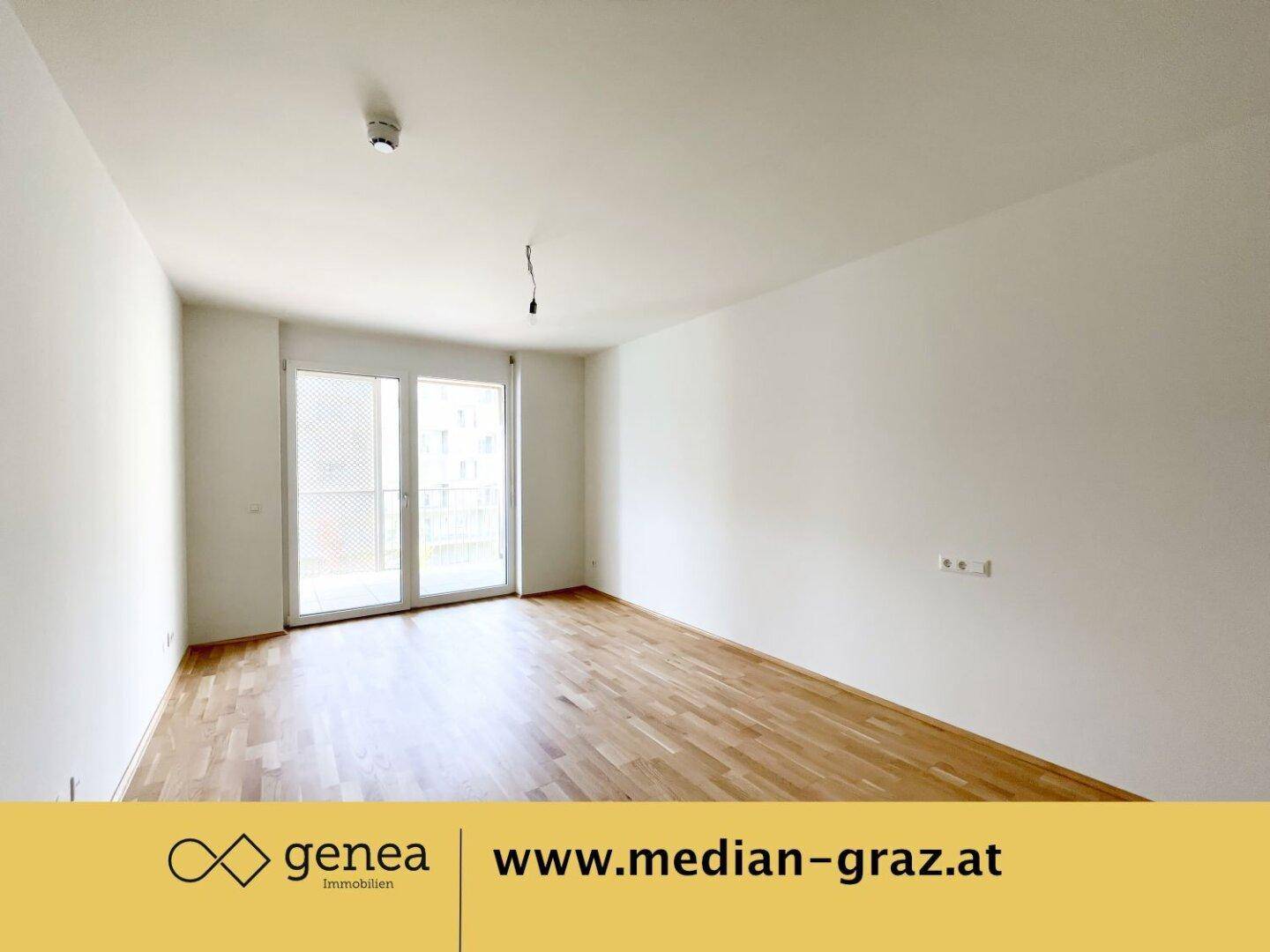 Geräumiges Wohnzimmer mit hellem Parkettboden und Zugang zu einem französischen Balkon.