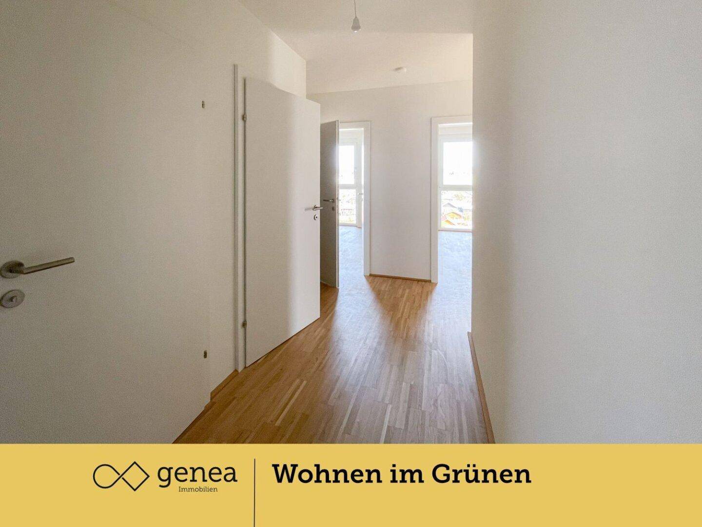 Heller Flur mit Parkettboden, weißen Wänden und Türen zu weiteren Räumen.