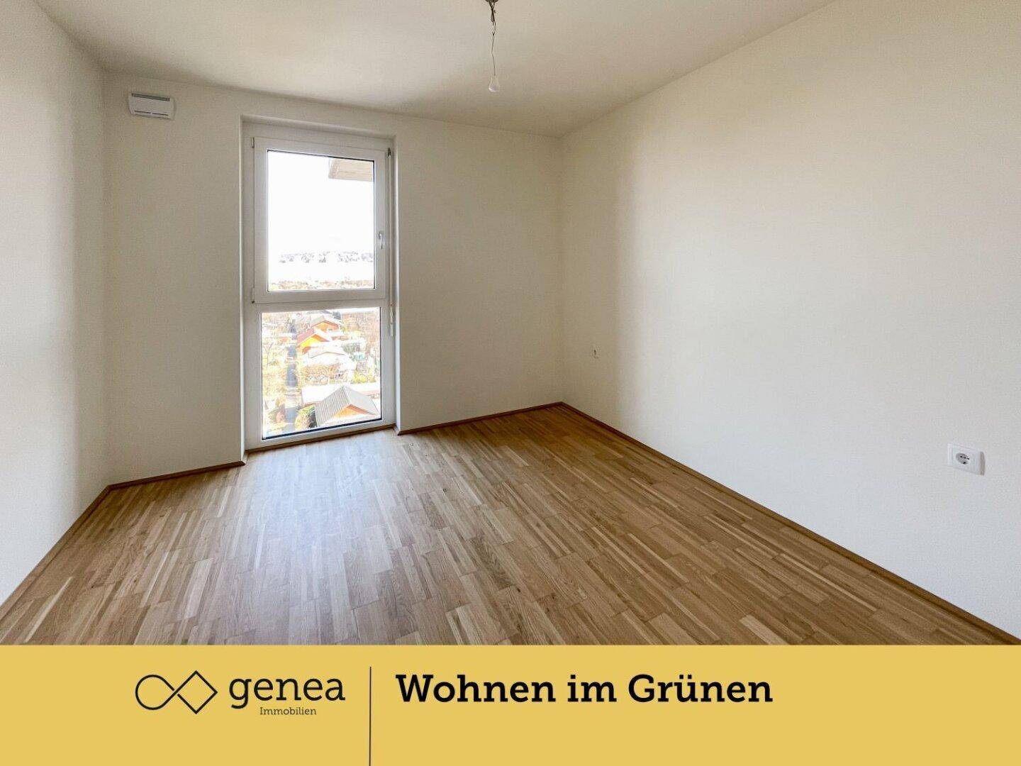 Freundliches Zimmer mit Parkettboden und Fenster, das viel Tageslicht hereinlässt.