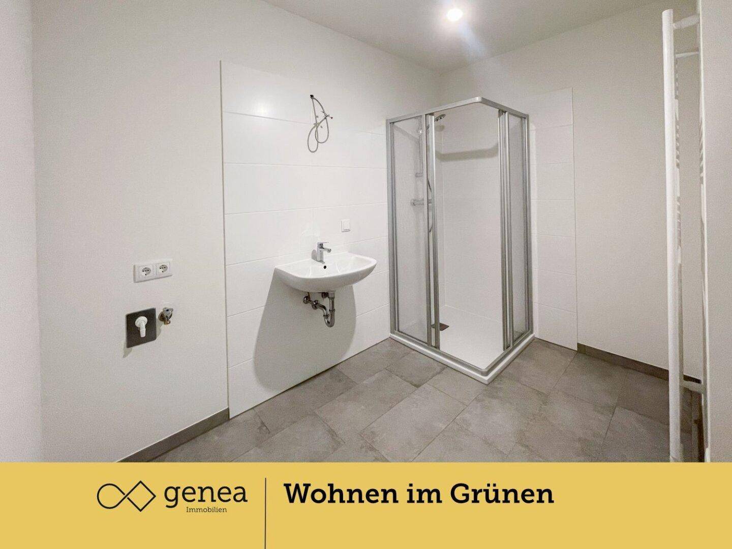Modernes Badezimmer mit Duschkabine, Waschbecken und grauen Fliesenboden.