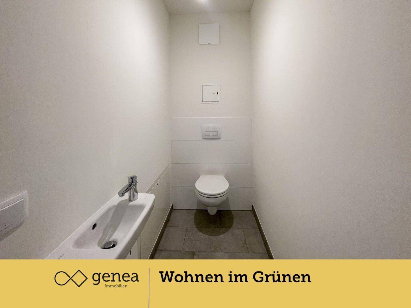 Kleines Gäste-WC mit wandhängender Toilette, schmalem Waschbecken und grauen Bodenfliesen.