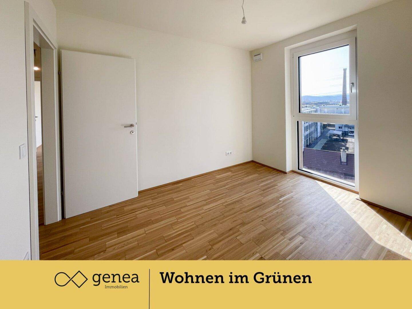 Helles Schlafzimmer mit Parkettboden und großem Fenster, das viel Tageslicht hereinlässt.