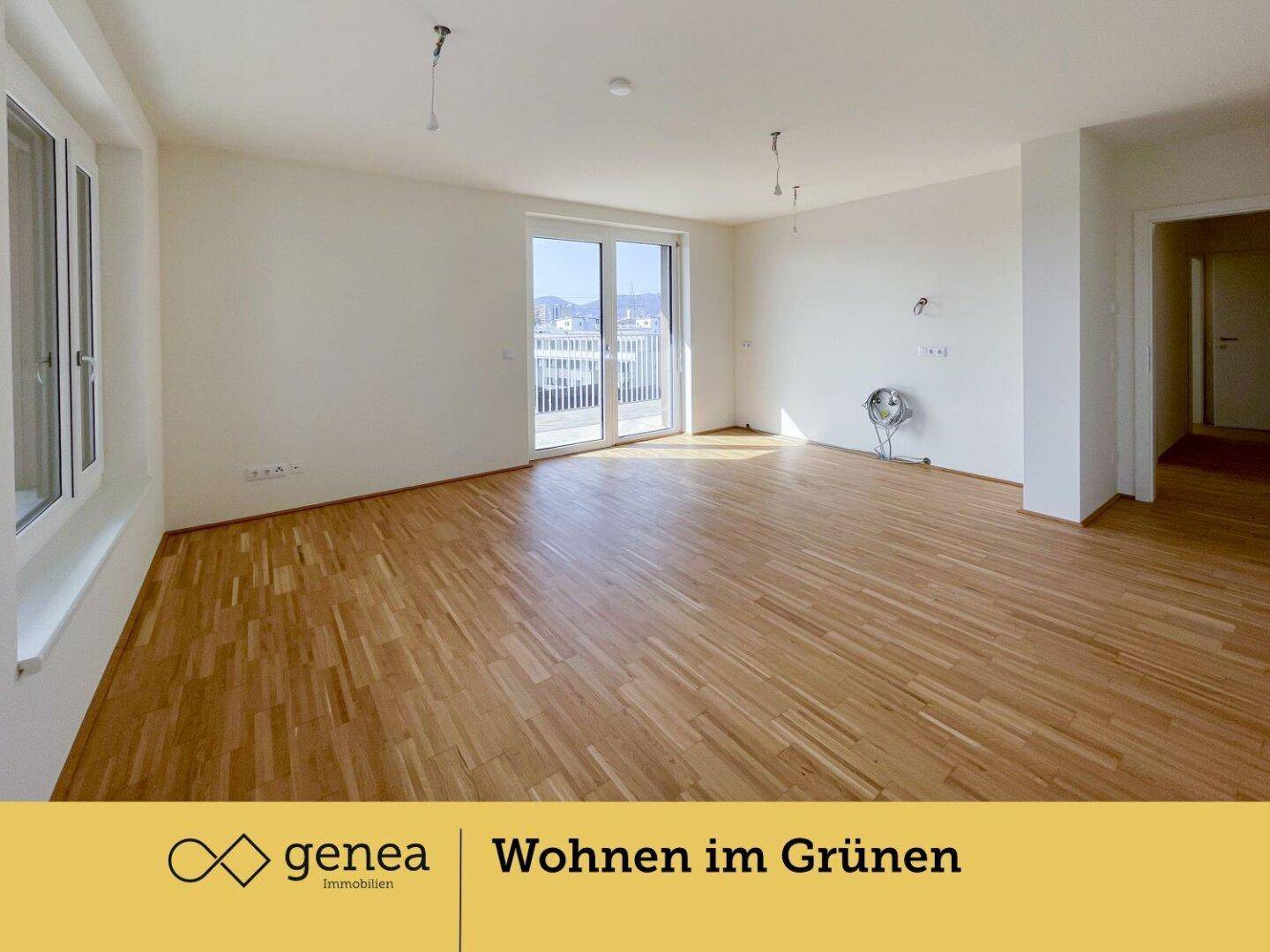Geräumiger Wohnbereich mit Parkettboden, Balkonzugang und Anschlüssen für eine Küche.