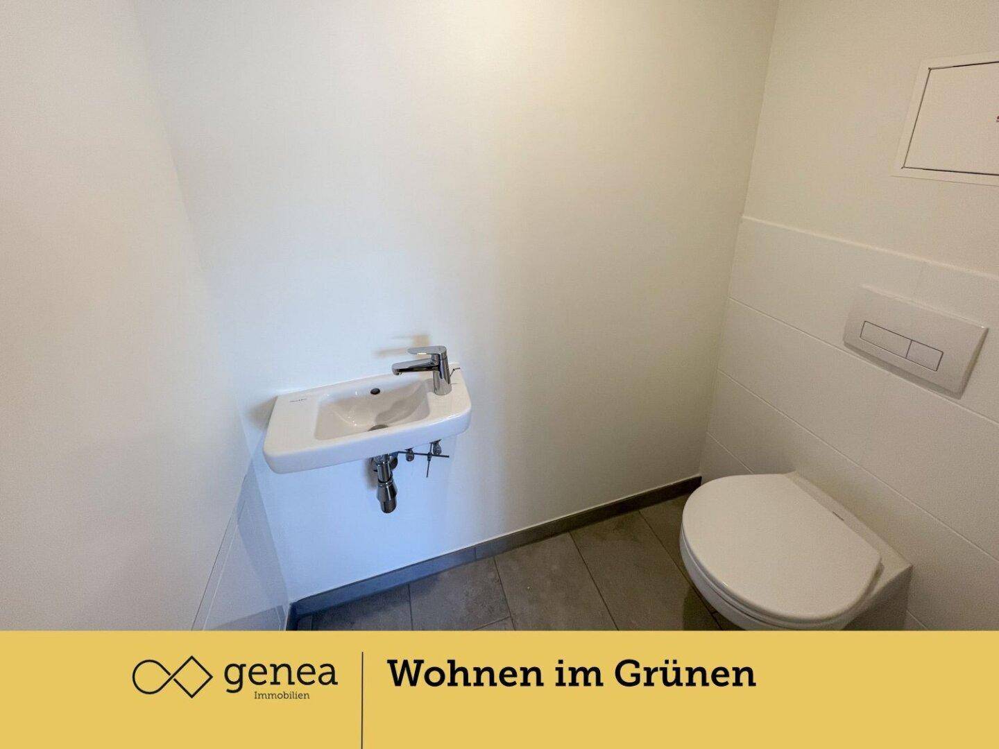 Modernes Gäste-WC mit wandhängender Toilette und kleinem Waschbecken, in neuwertigem Zustand.