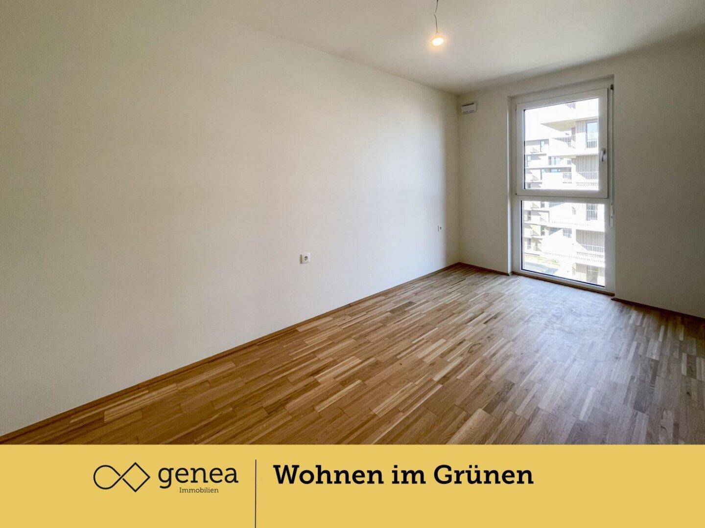 Helles Schlafzimmer mit Parkettboden und großem Fenster, das viel Tageslicht hereinlässt.