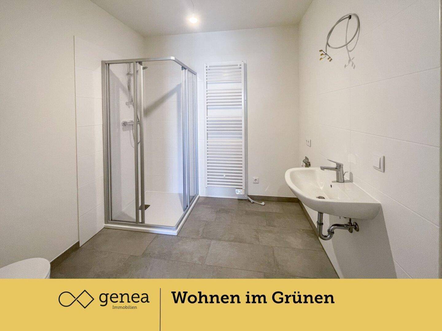 Modernes Badezimmer mit ebenerdiger Dusche, Einzelwaschbecken und beheiztem Handtuchhalter.