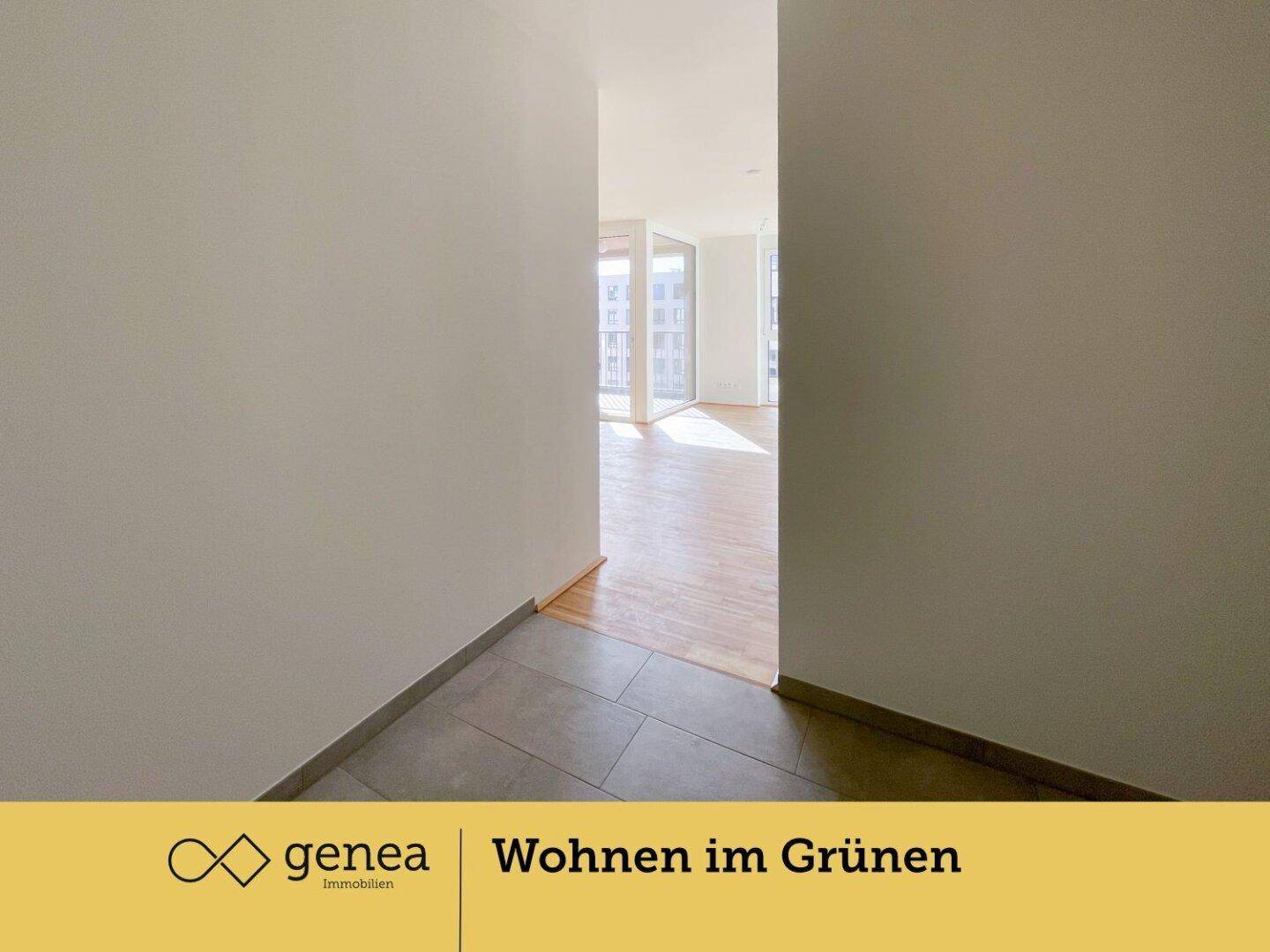 Heller Flur mit modernen Fliesen, der in einen Raum mit Parkettboden übergeht.