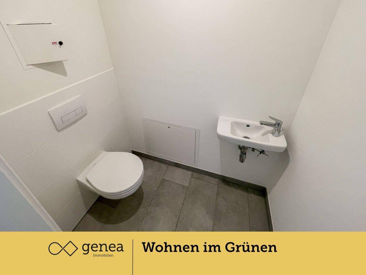 Kleines Gäste-WC mit wandhängender Toilette und einem kompakten Handwaschbecken.