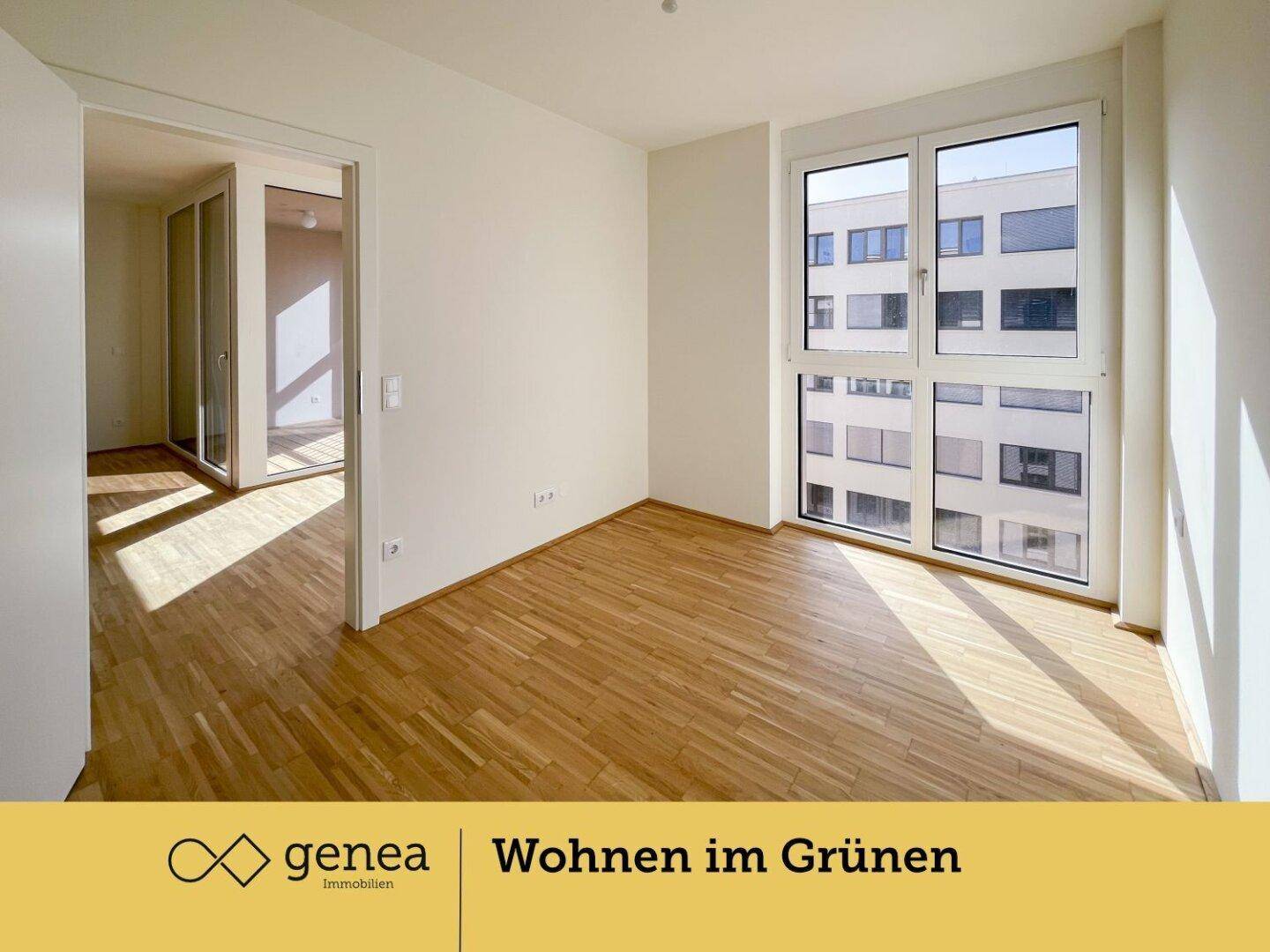 Helles Zimmer mit Parkettboden und großen Fenstern, die viel Tageslicht hereinlassen.