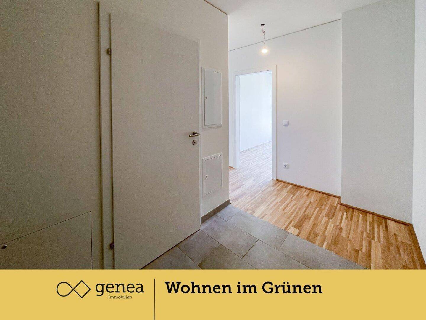 Eingangsbereich mit Fliesenboden, der in einen hellen Flur mit Parkett übergeht.