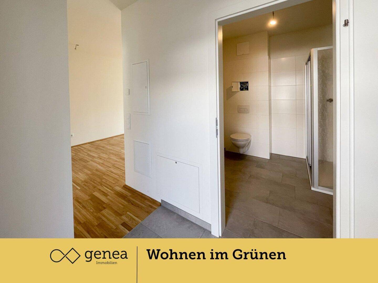 Flur mit Zugang zu einem Badezimmer, das eine Toilette und eine Dusche umfasst.
