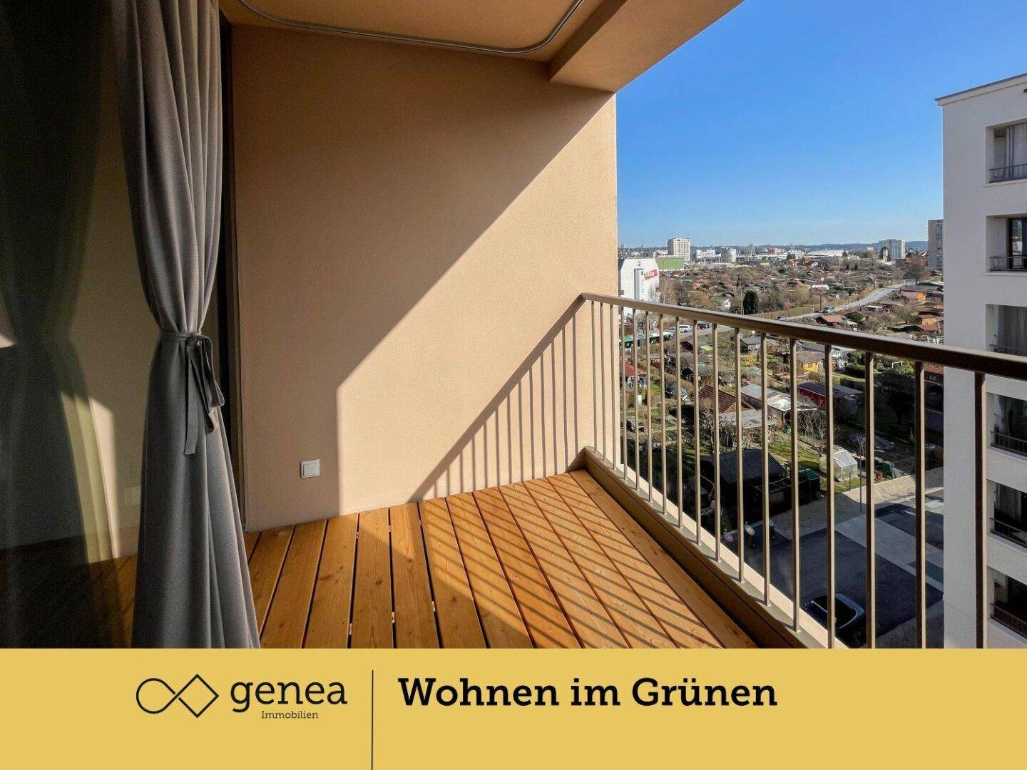 Sonniger Balkon mit Holzboden und Metallgeländer, bietet einen weiten Blick über die Stadt.