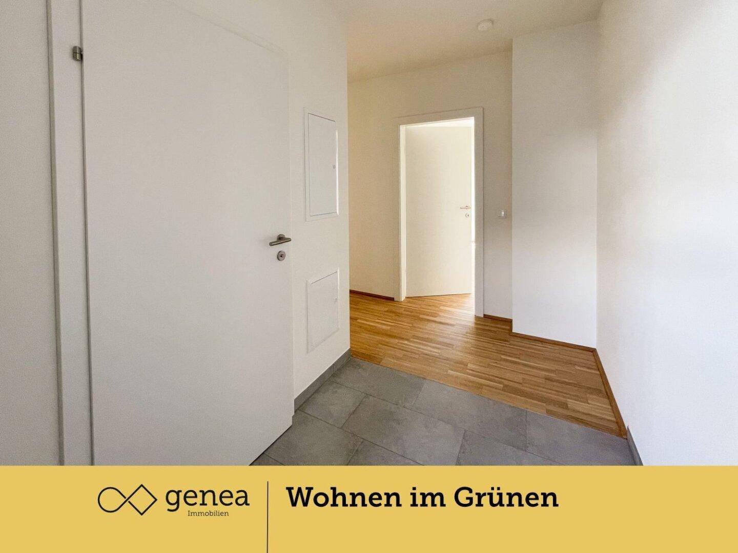 Heller Eingangsbereich mit Fliesenboden, der in Parkett übergeht, und weißen Türen.