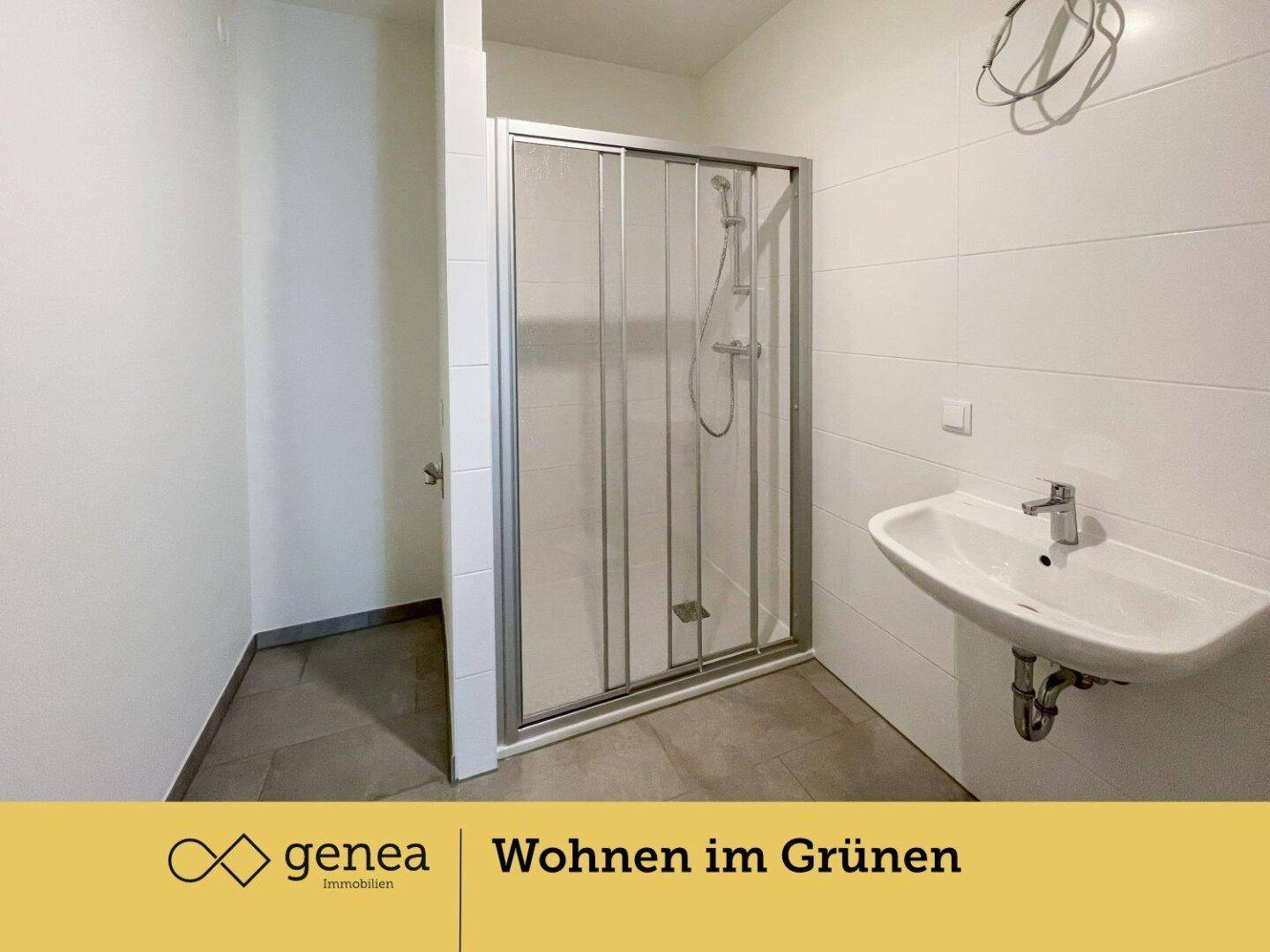 Modernes Badezimmer mit Duschkabine, Waschbecken und hellen Fliesen.