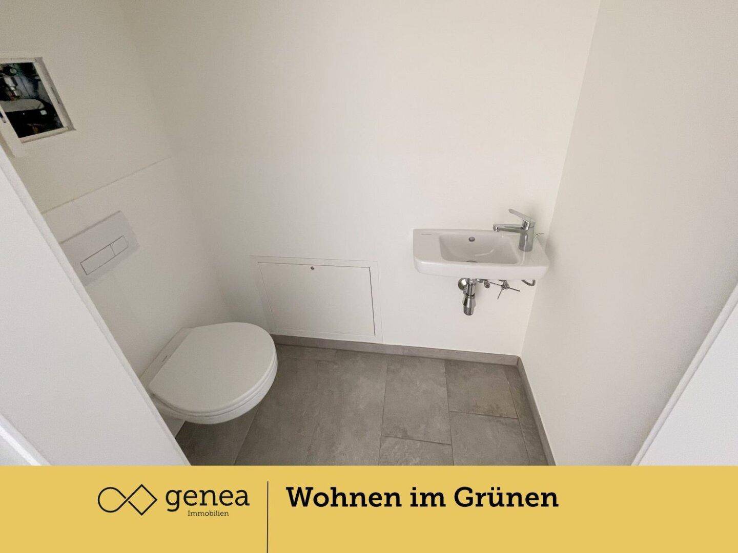 Modernes Gäste-WC mit wandhängendem WC, kleinem Waschbecken und grauen Bodenfliesen.