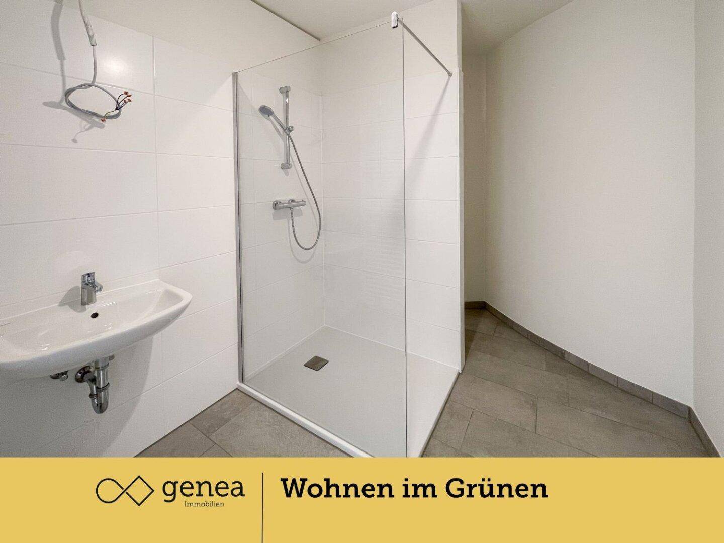 Modernes Badezimmer mit ebenerdiger Dusche, Waschbecken und weißen Wandfliesen.