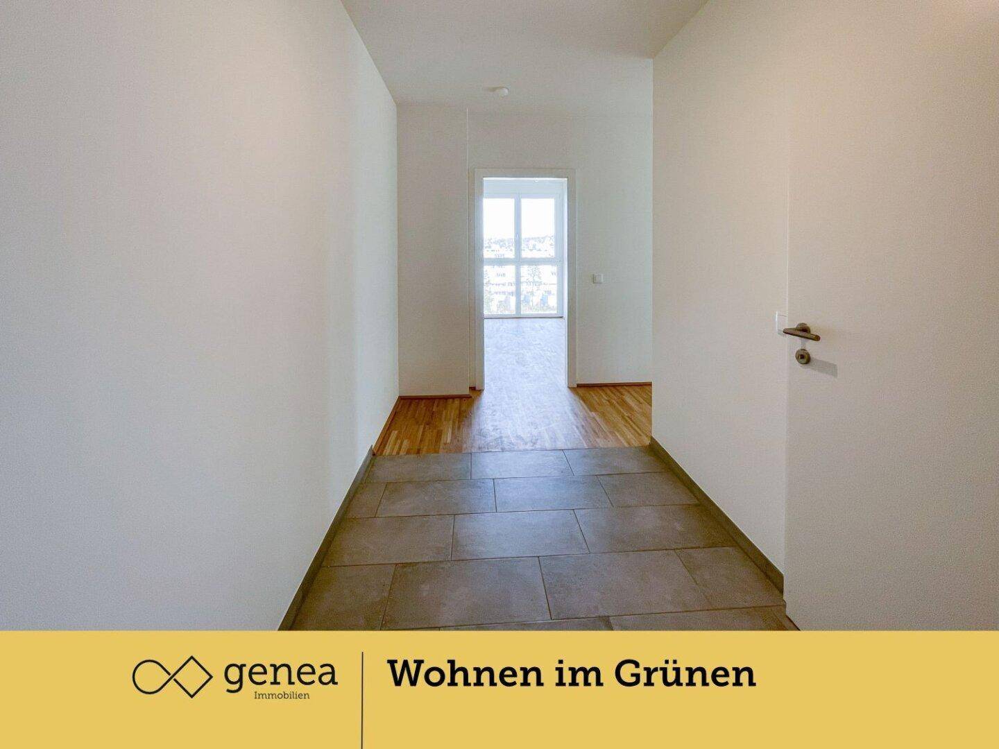 Heller Flur mit Fliesenboden im Eingangsbereich, der zu weiteren Räumen mit Parkett führt.