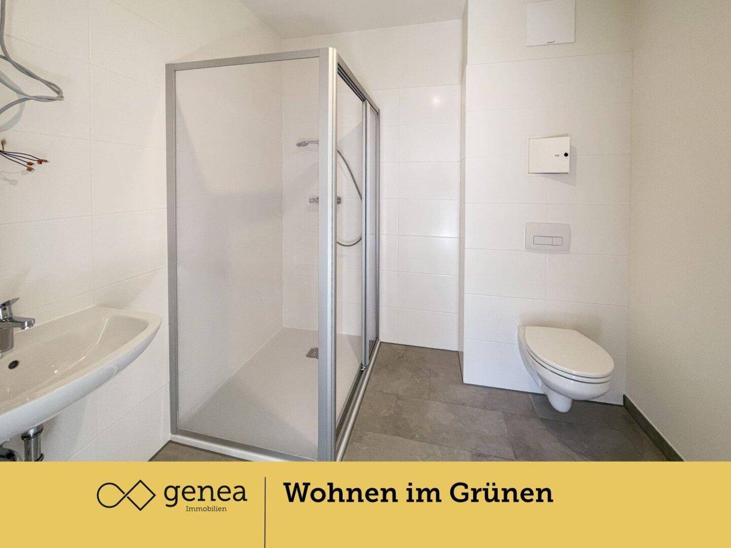 Modernes Badezimmer mit Duschkabine, wandhängendem WC und Waschbecken.