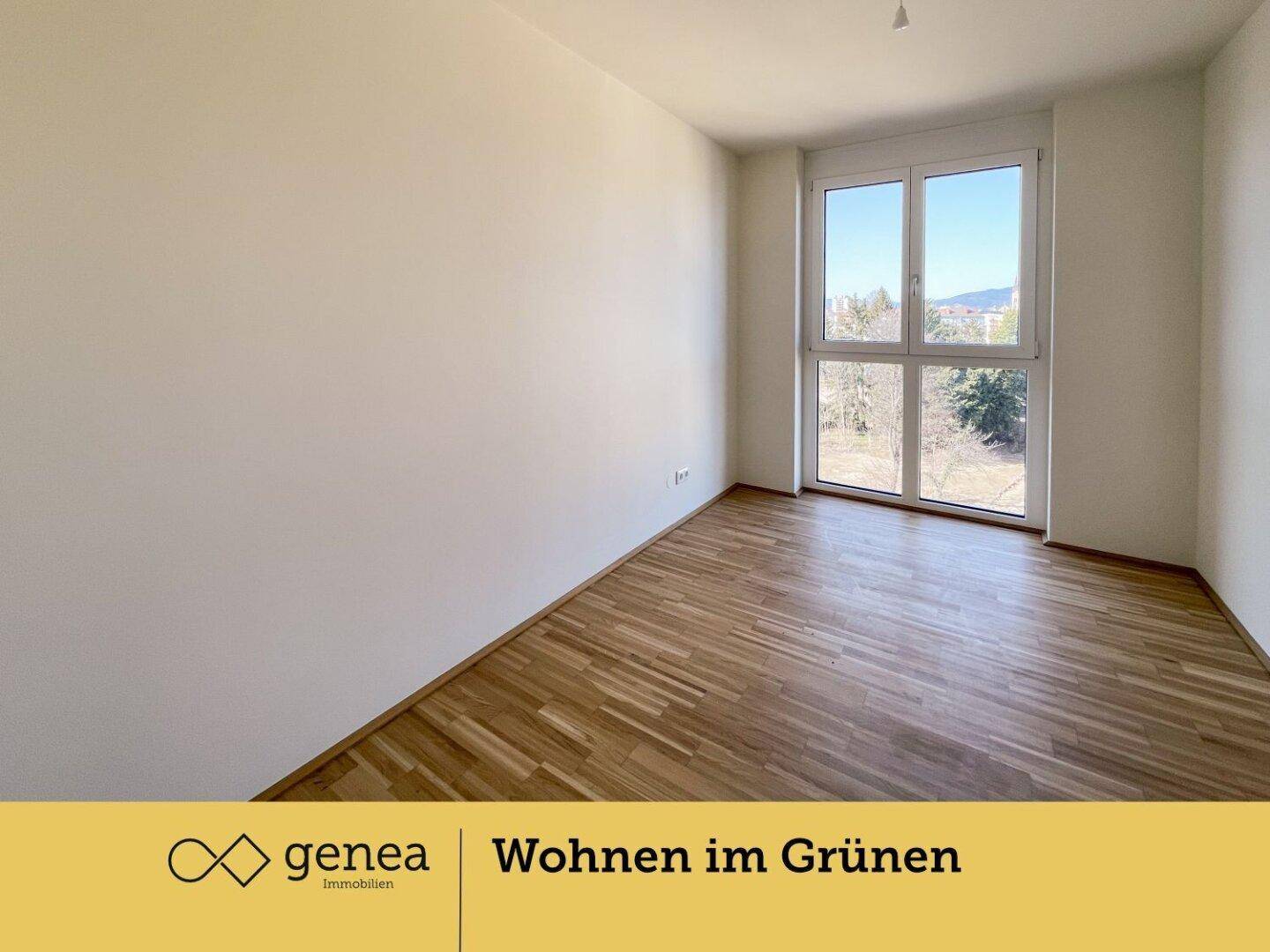 Helles Schlafzimmer mit Parkettboden und großem Fenster mit Ausblick ins Grüne.