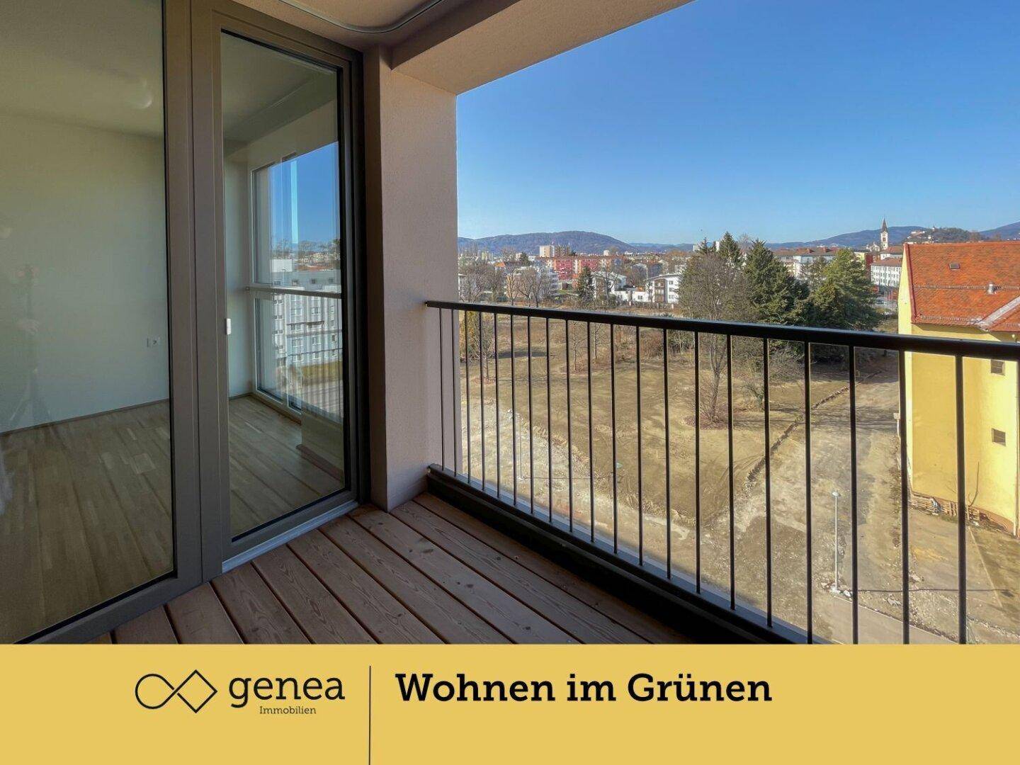 Balkon mit Holzboden und Metallgeländer bietet einen weiten Blick ins Grüne.