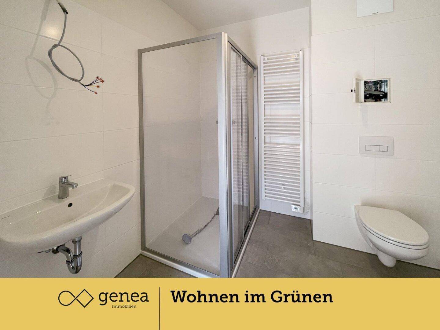 Modernes Badezimmer mit Duschkabine, wandhängendem WC und beheiztem Handtuchhalter.