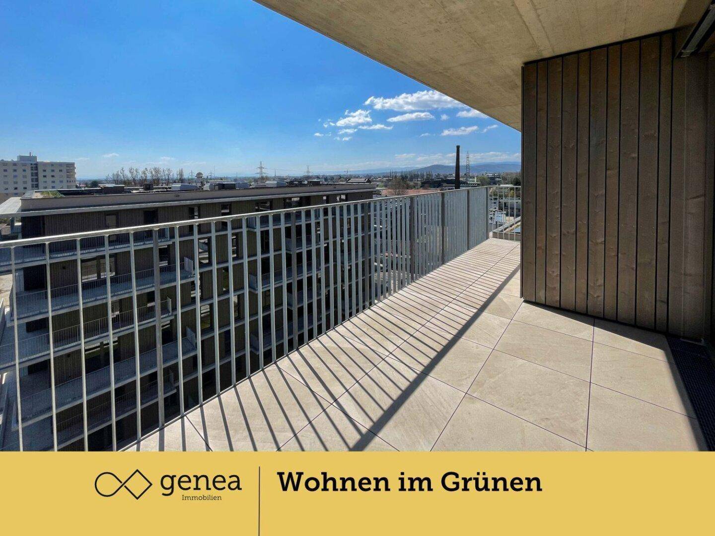 Heller Balkon mit Fliesenboden und Blick auf die Nachbargebäude und die Ferne.