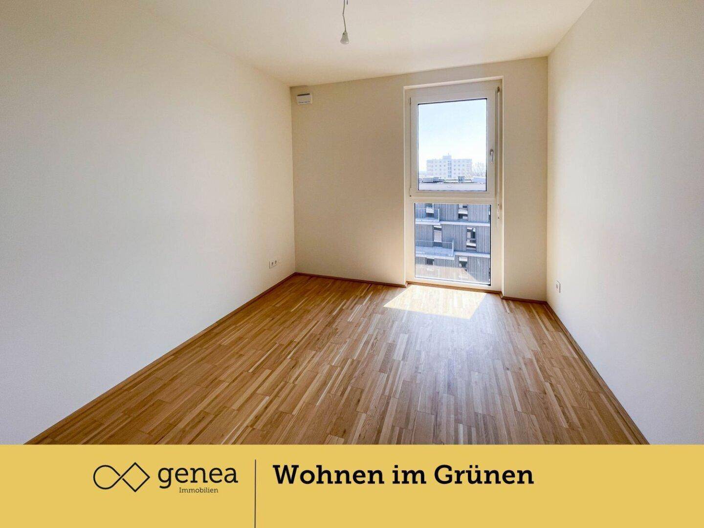 Helles Schlafzimmer mit Parkettboden und großem Fenster mit Blick auf die Umgebung.