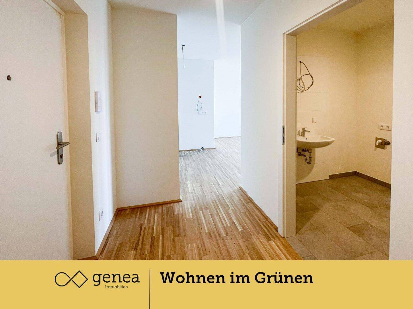 Heller Flur mit Holzparkettboden und Blick in einen weiteren Raum sowie ein Badezimmer.
