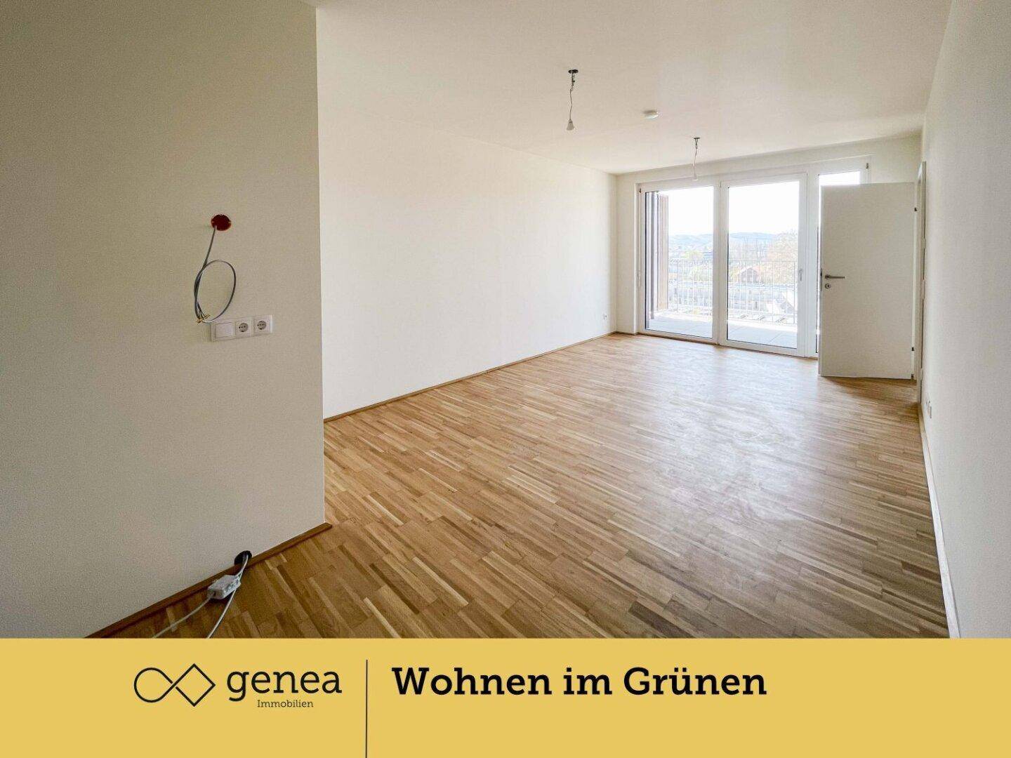 Leeres, helles Zimmer mit Holzparkettboden und großen Fenstern, die Zugang zu einem Balkon bieten.