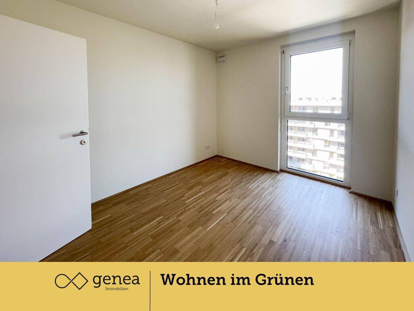 Helles Schlafzimmer mit Parkettboden und großem Fenster, das viel Tageslicht hereinlässt.