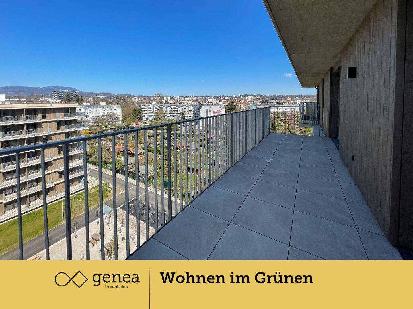 Langer Balkon mit Fliesen und Blick auf die umliegende Bebauung und Grünflächen.