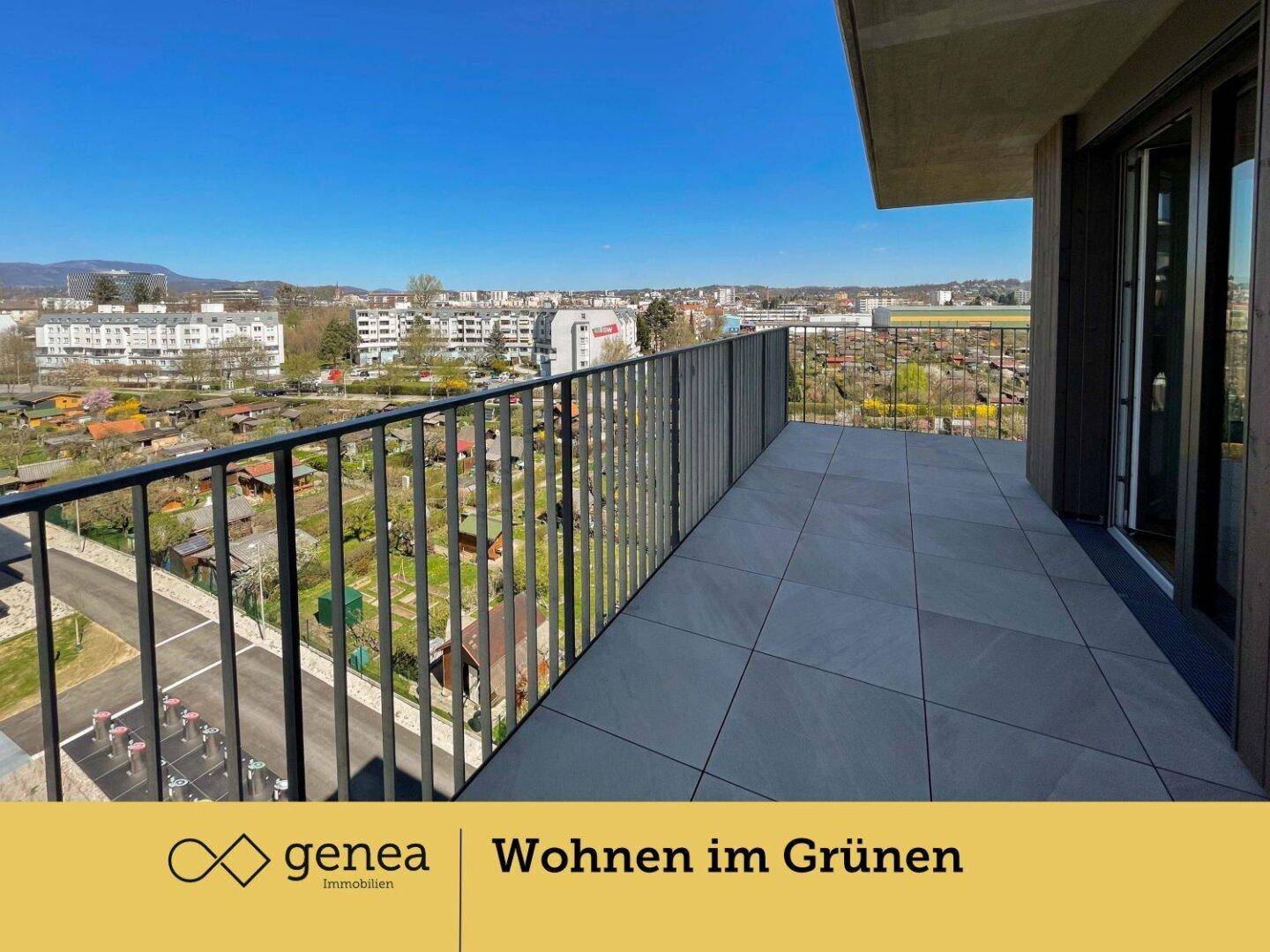 Breiter Balkon mit Fliesenboden und weitreichendem Blick über die Stadt und grüne Flächen.