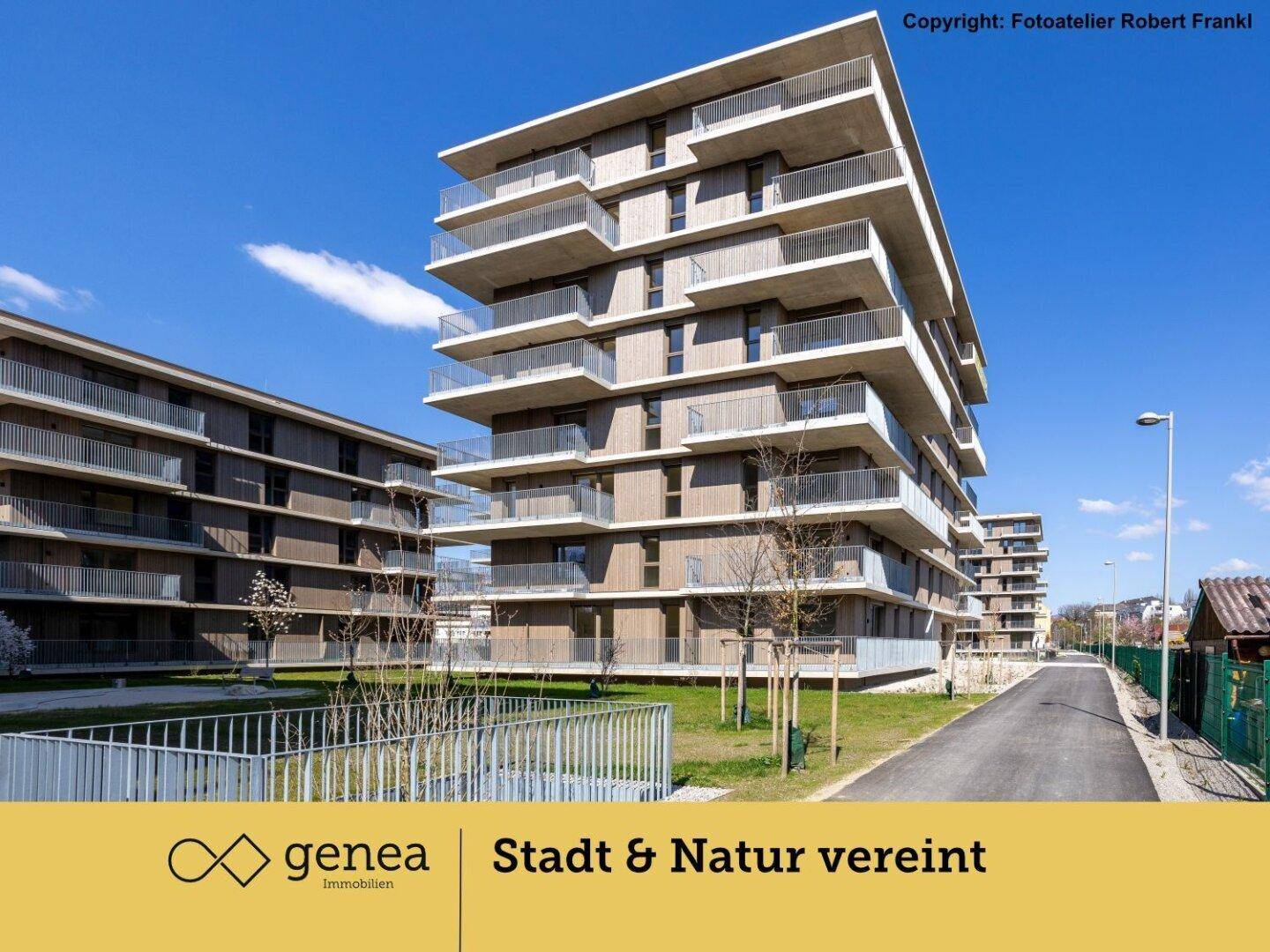 Moderne Wohngebäude mit zahlreichen Balkonen und klarer Architektur unter blauem Himmel.