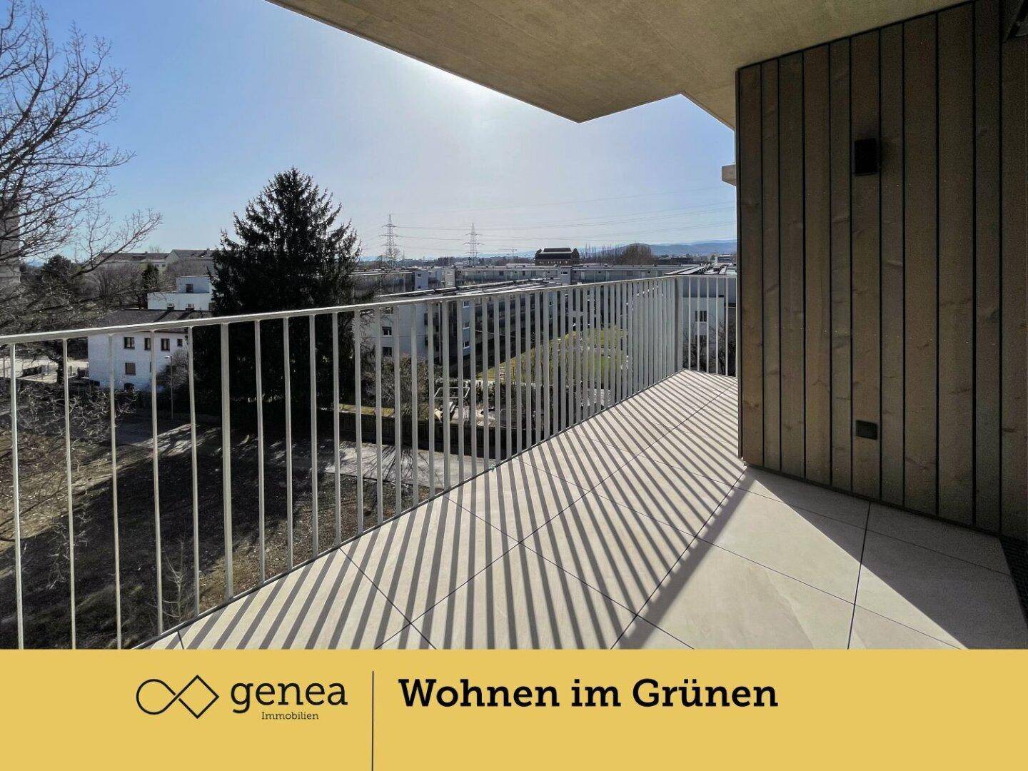 Sonniger Balkon mit Fliesenboden und weitem Blick über die Stadt und Natur.