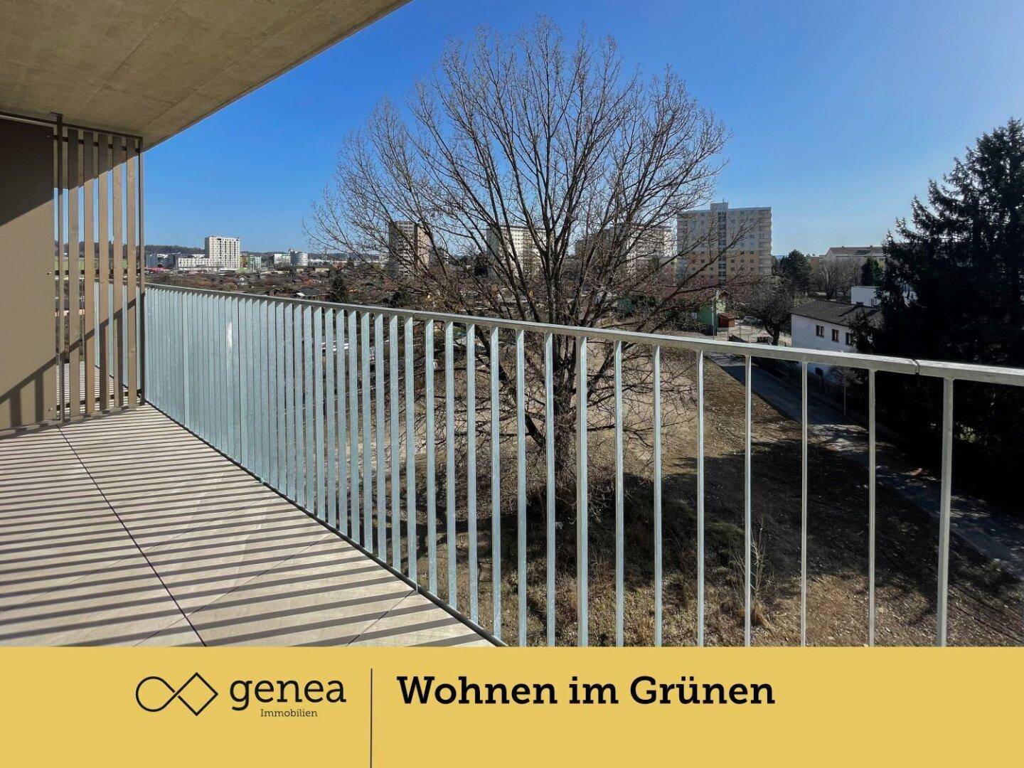 Geräumiger Balkon mit Metallgeländer und Blick auf Bäume und die Umgebung.