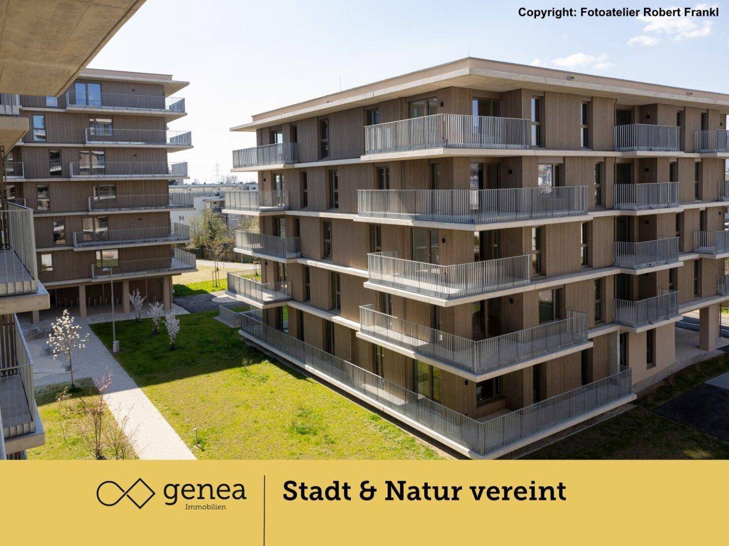 Moderne Wohngebäude mit Holzfassaden und Balkonen, umgeben von grünen Rasenflächen.