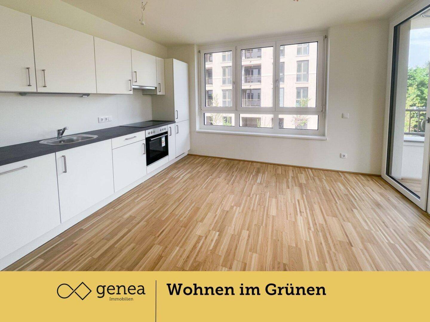 Moderne Einbauküche mit weißen Schränken, dunkler Arbeitsplatte und Parkettboden.