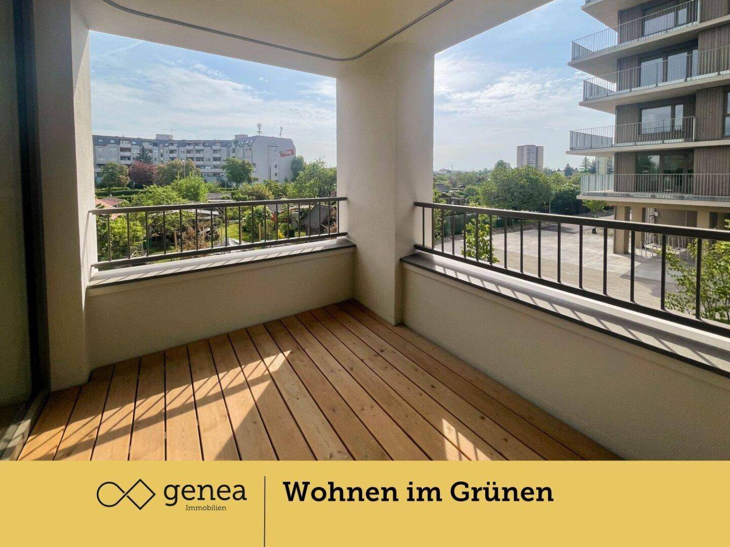 Geräumiger Balkon mit Holzboden und Blick auf die umliegenden Gebäude und Grünflächen.