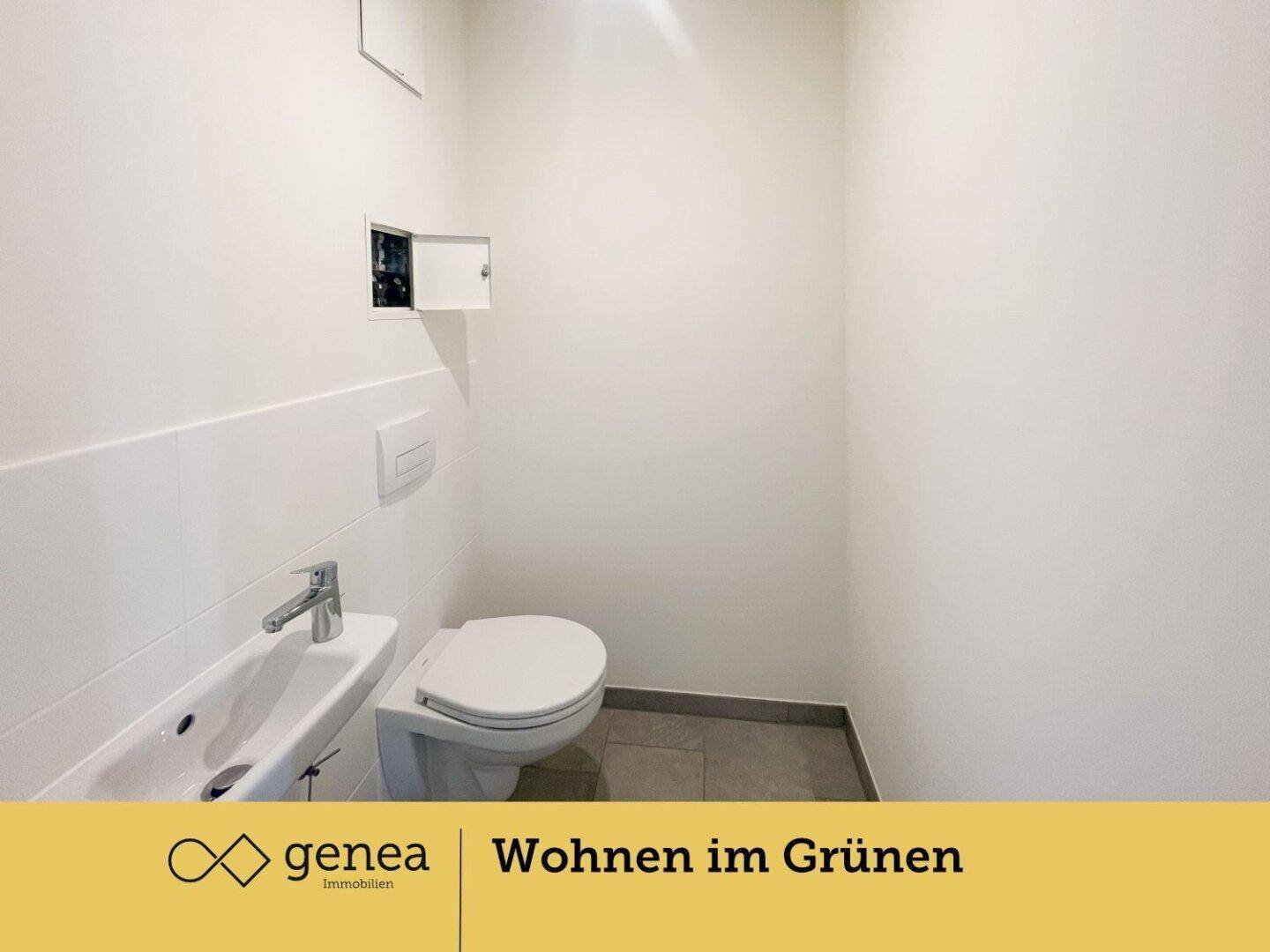 Modernes Gäste-WC mit wandhängender Toilette, kleinem Waschbecken und Fliesenboden.