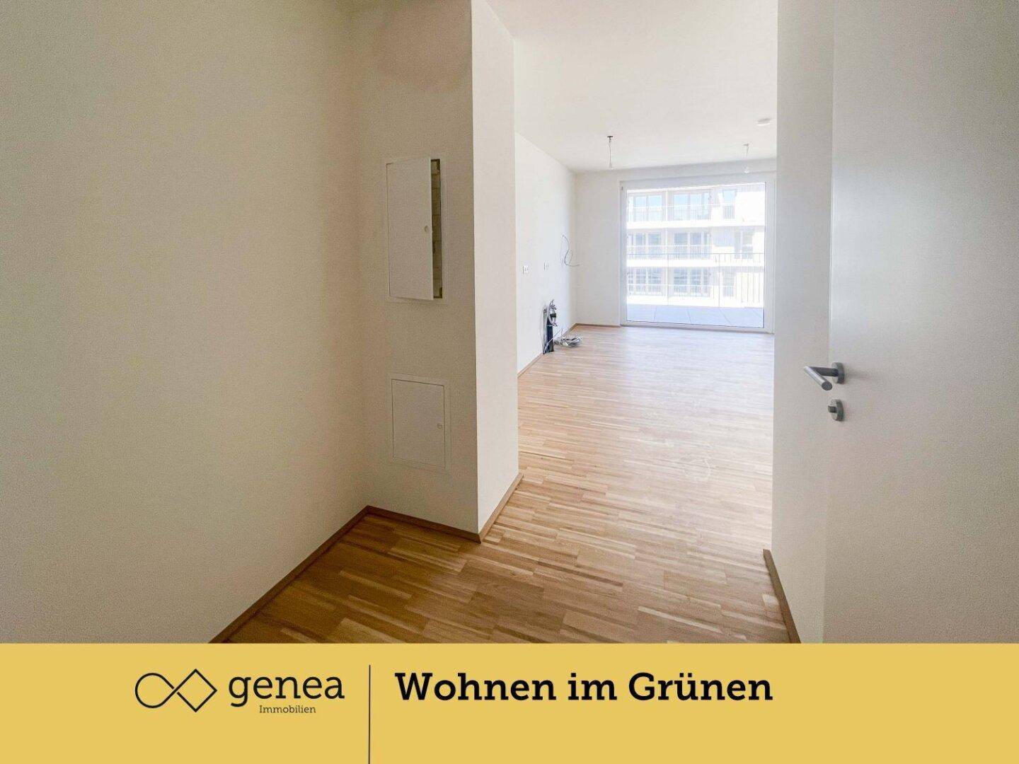 Heller Flur mit Holzparkettboden, der in einen lichtdurchfluteten Wohnbereich führt.