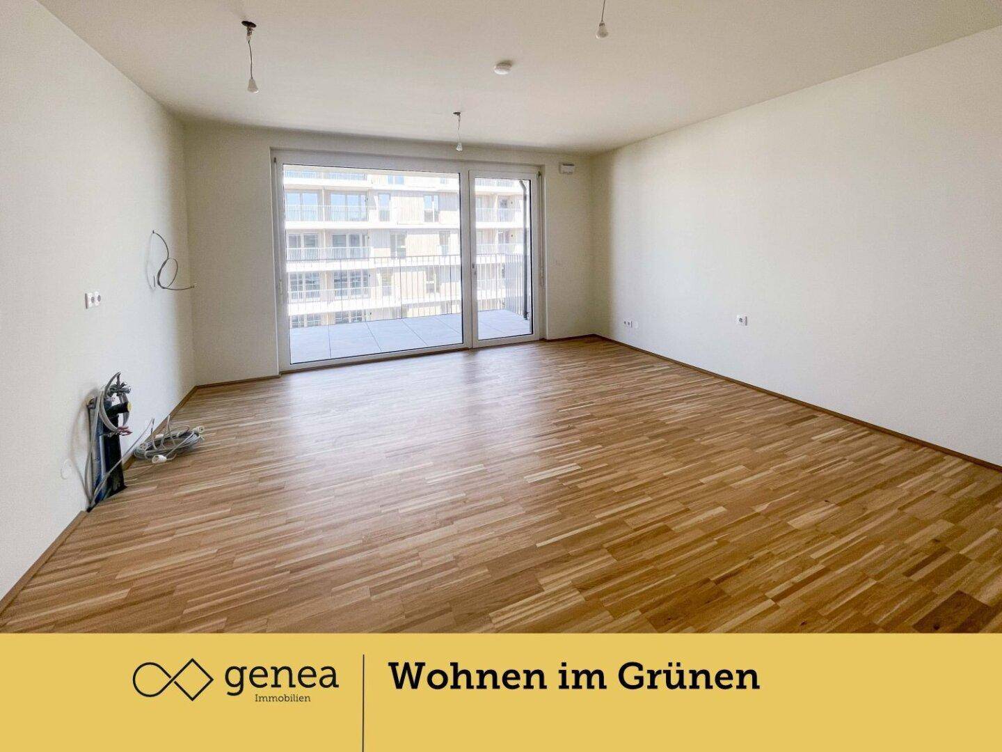 Geräumiger, heller Wohnraum mit Holzparkettboden und großen Fenstern zum Balkon.