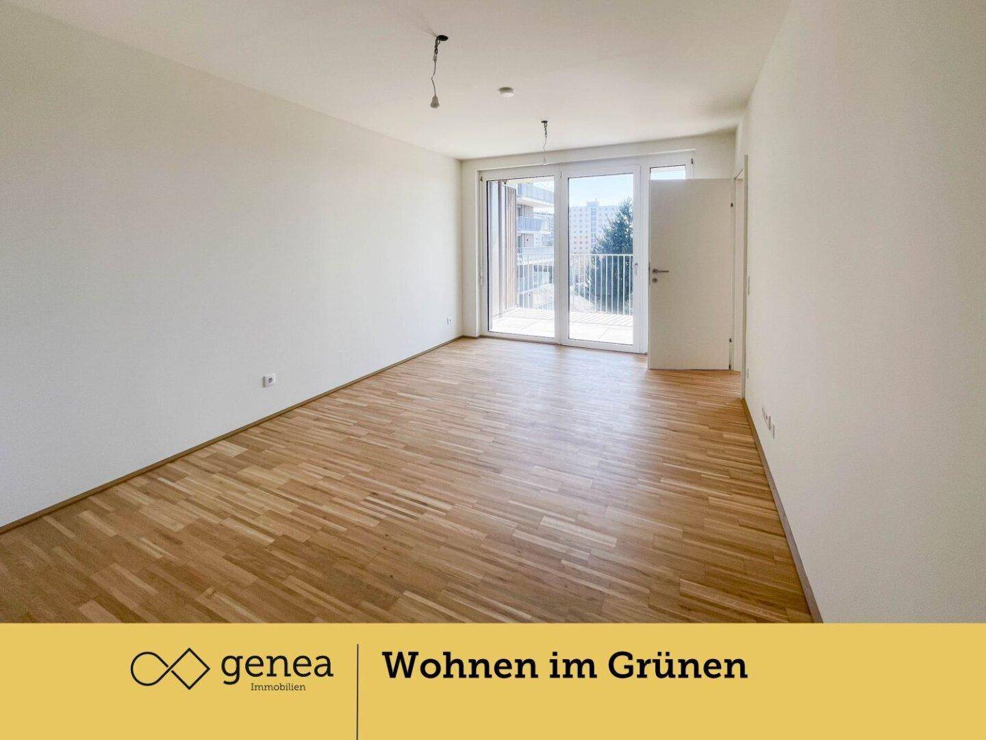 Geräumiger, heller Raum mit Holzparkettboden und großen Fenstern mit französischem Balkon.