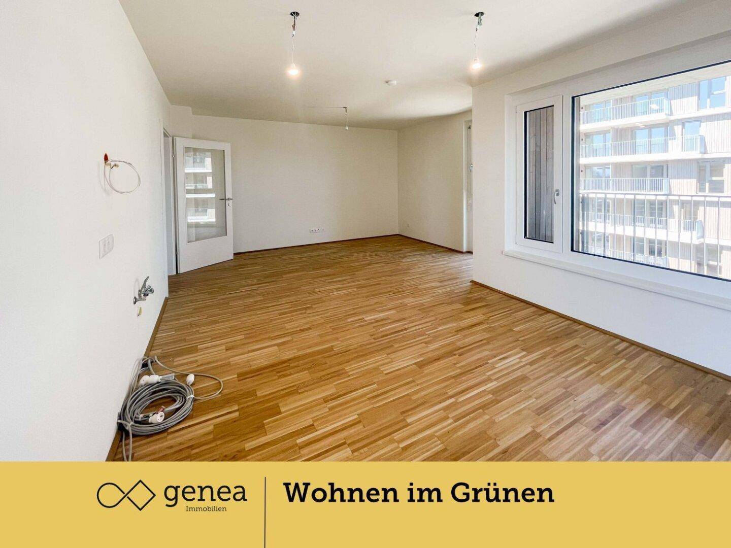 Geräumiges, unmöbliertes Wohnzimmer mit Holzboden und großen Fenstern, ideal für offenes Wohnen.