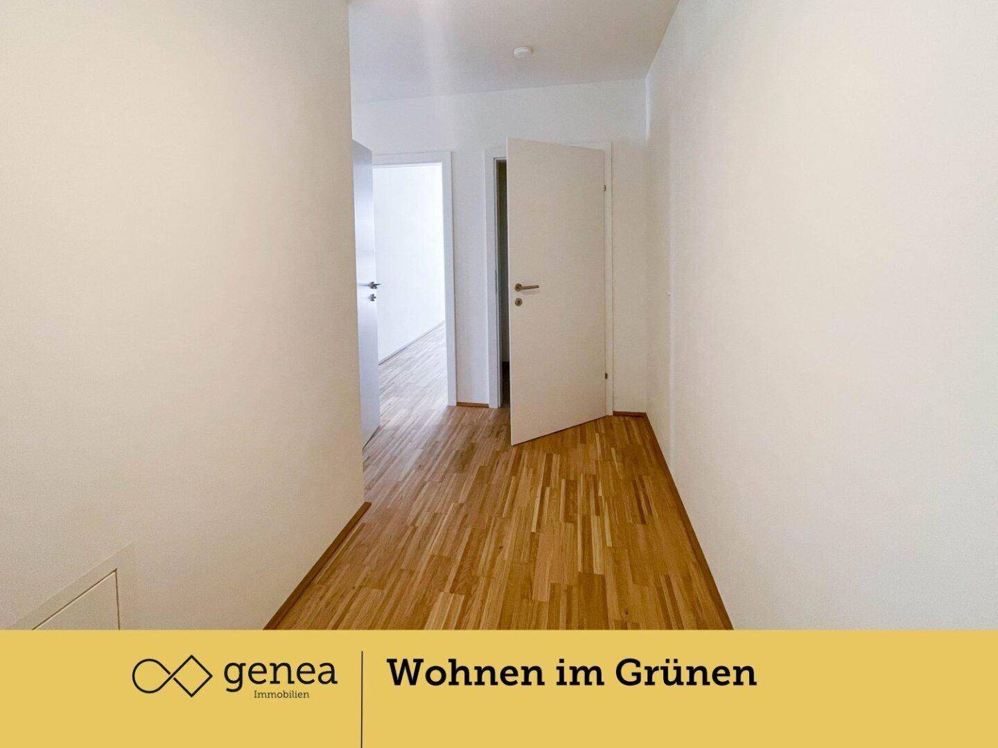 Heller Flur mit Parkettboden und weißen Wänden, der zu weiteren Räumen führt.