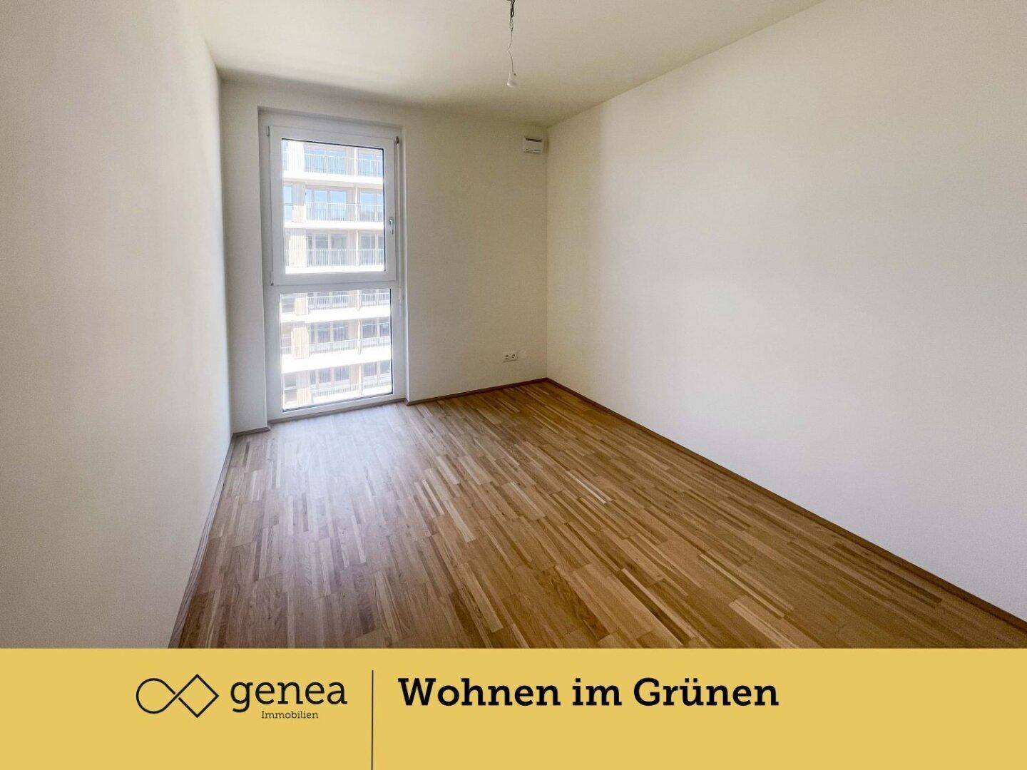 Helles Schlafzimmer mit Parkettboden und einem großen Fenster, das viel Tageslicht hereinlässt.